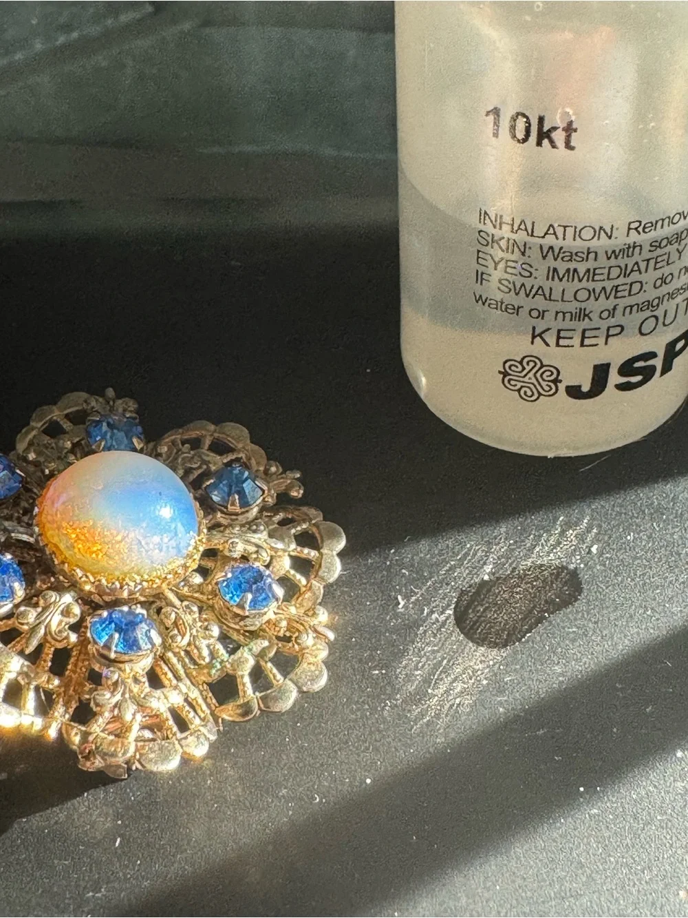 Gold-Tone Floral Brooch with Blue Crystal Accents and Iridescent Center